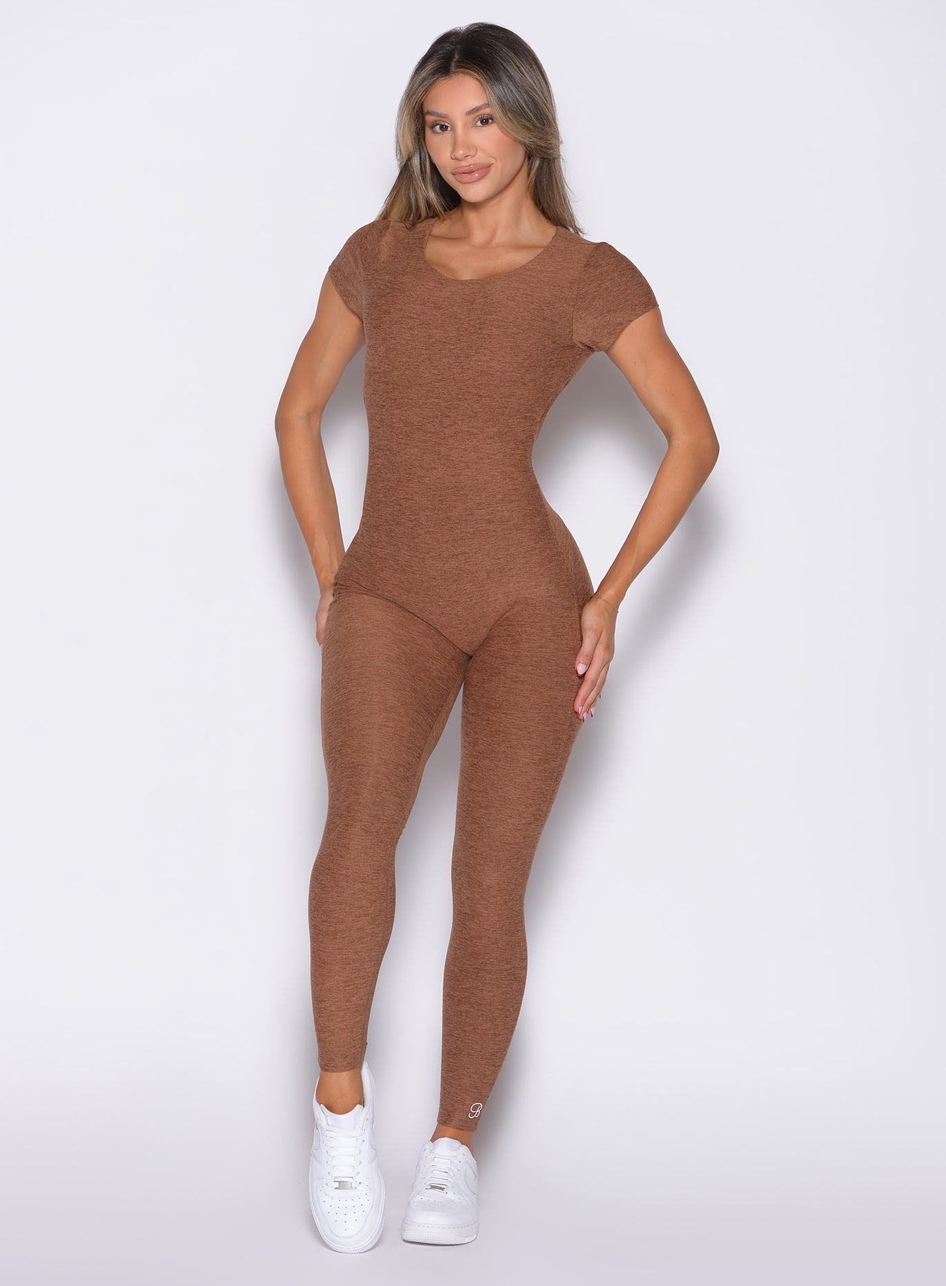 front profile view of a model with both hands on her thighs wearing the Open Back Tee Bodysuit in Coffee Bean color