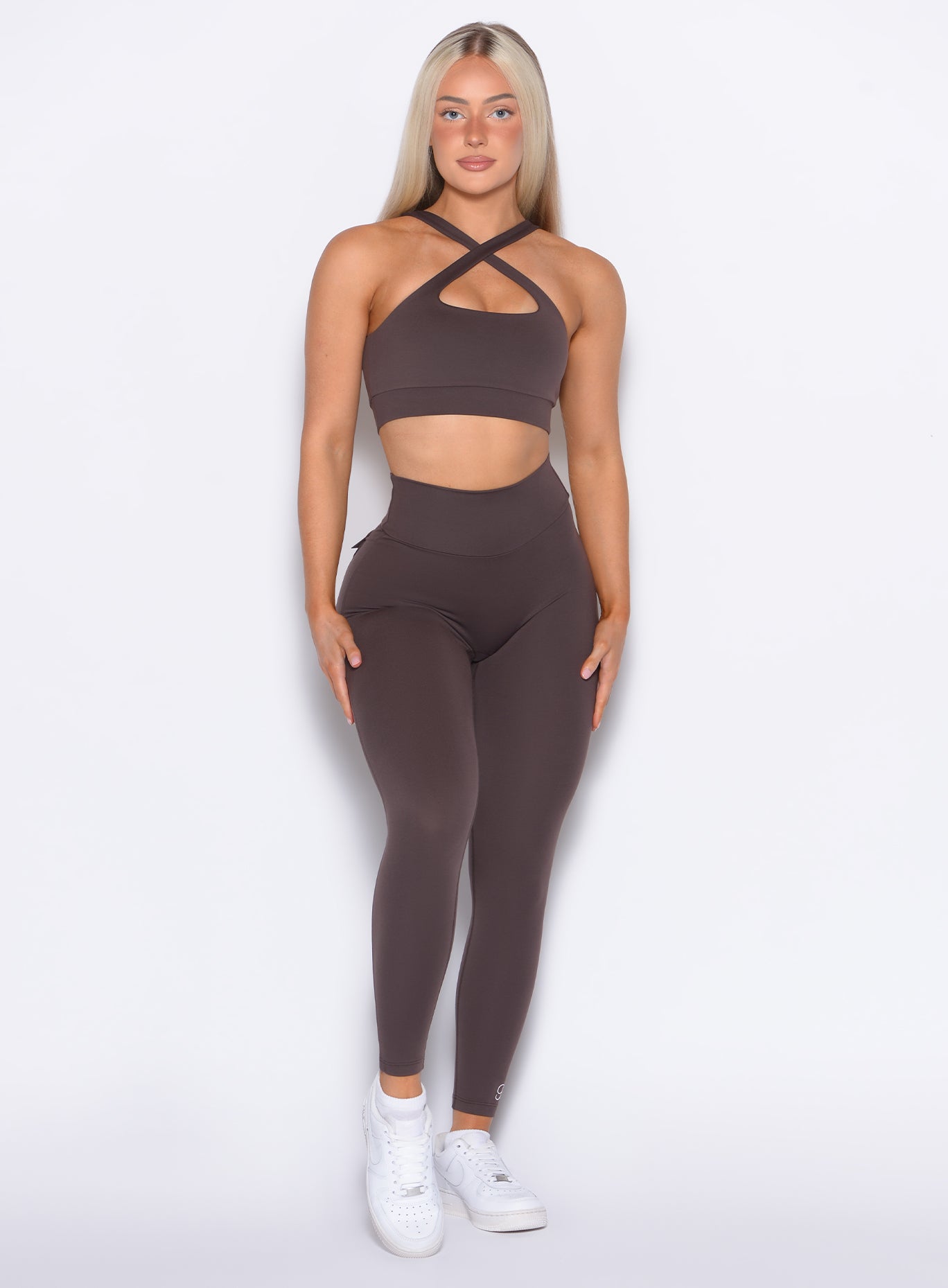 Model facing forward wearing our Pocket Pop Leggings 2.0 in Seal Brown color and the matching bra