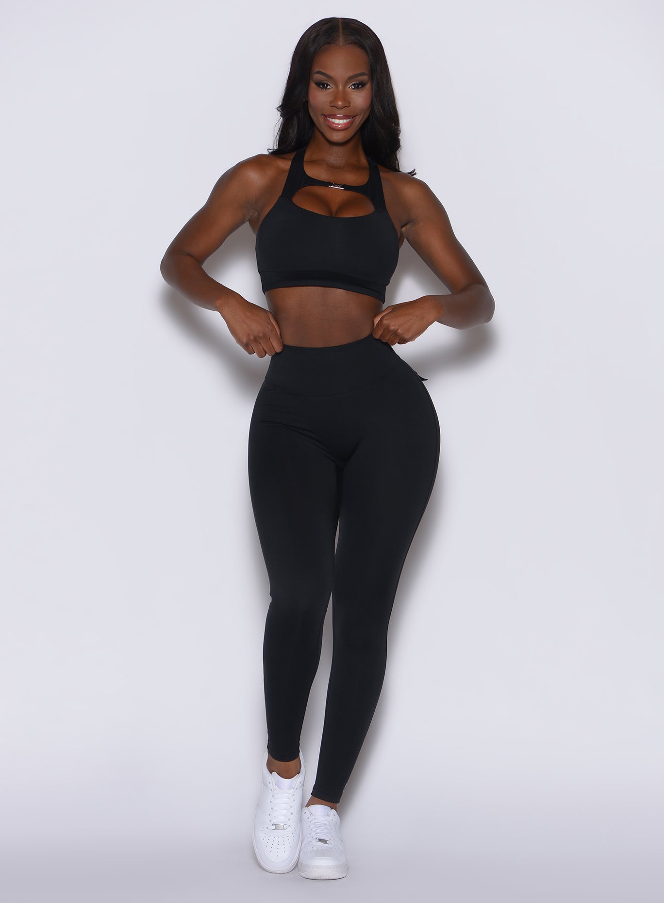 front profile view of a model wearing our black pocket pop leggings along with the matching bra