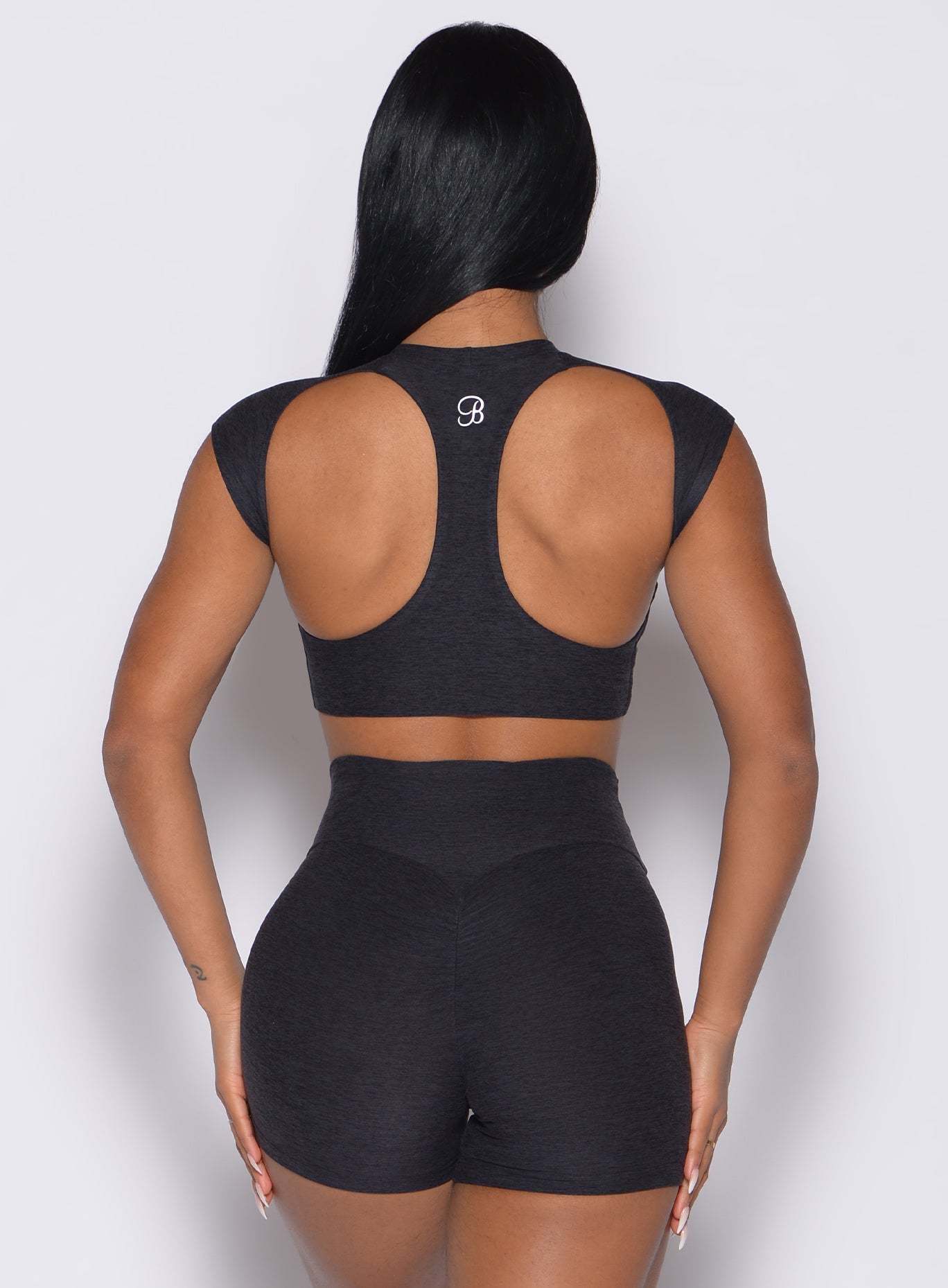 back profile view of a model wearing the Core Strength Tee in Heathered Black color
