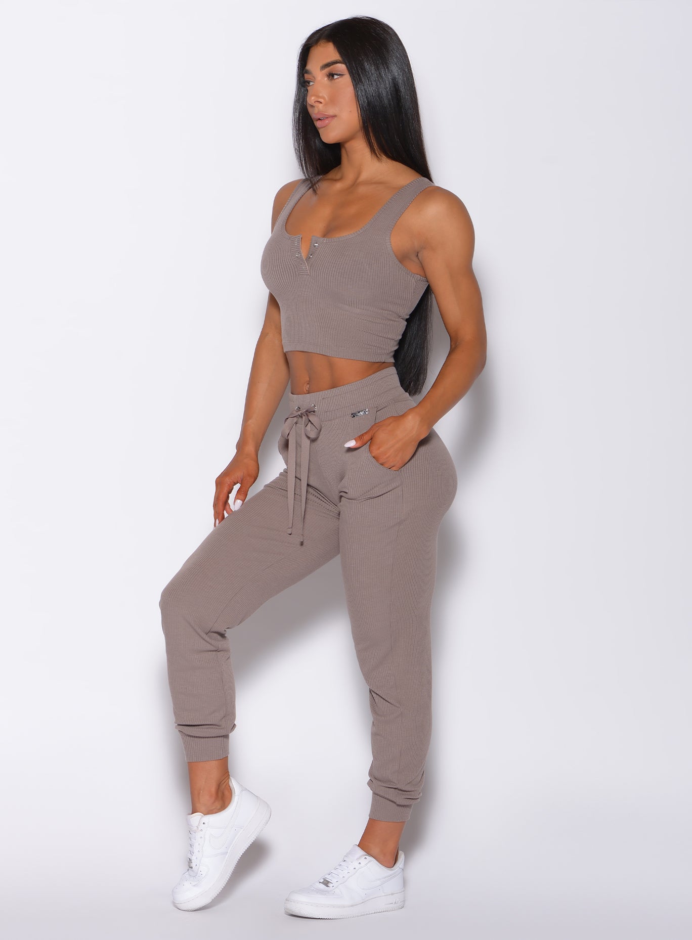 left side profile view of a model angled left wearing our comfort rib joggers in navy and a matching bra