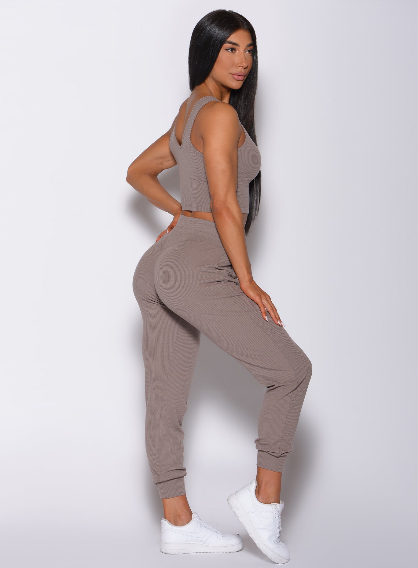 right side profile view of a model in our comfort rib joggers in navy and a matching bra