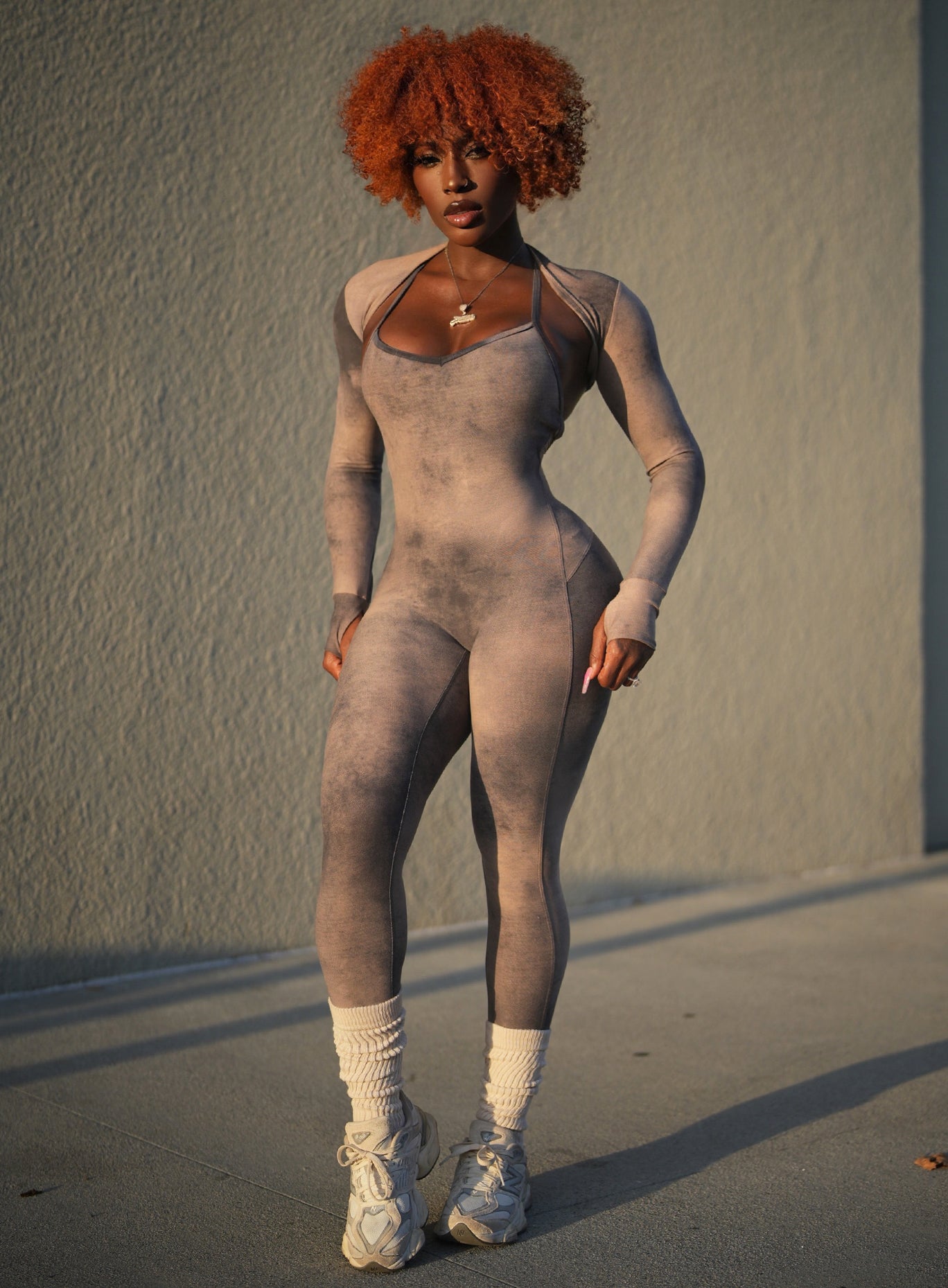 Front profile view of a model in our Sculpt Bodysuit in Vintage sand color along with the matching bombshell shape shrug