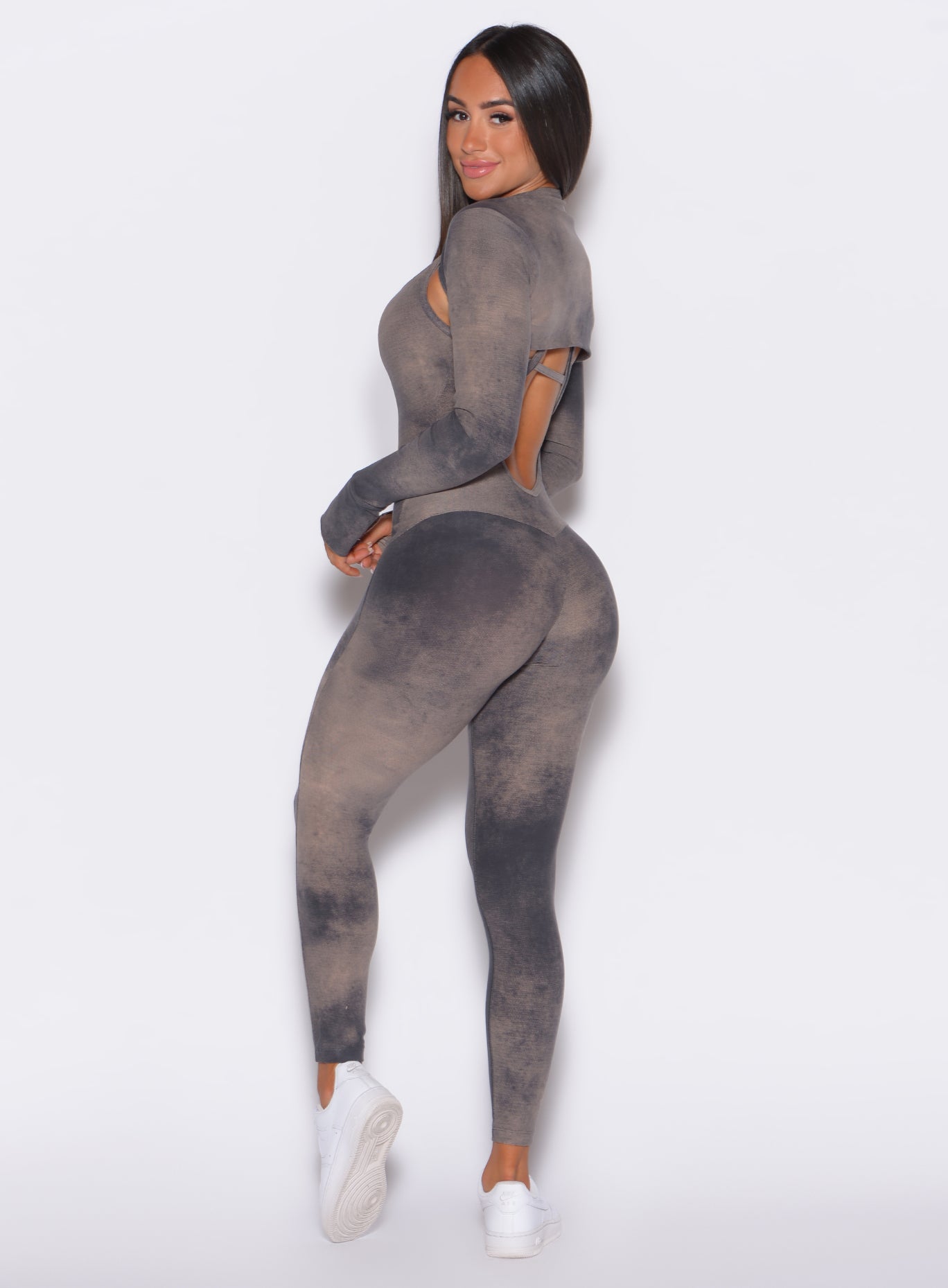 Left side profile view of a model facing to her left wearing our Sculpt Bodysuit in Vintage sand color along with the matching shape shrug