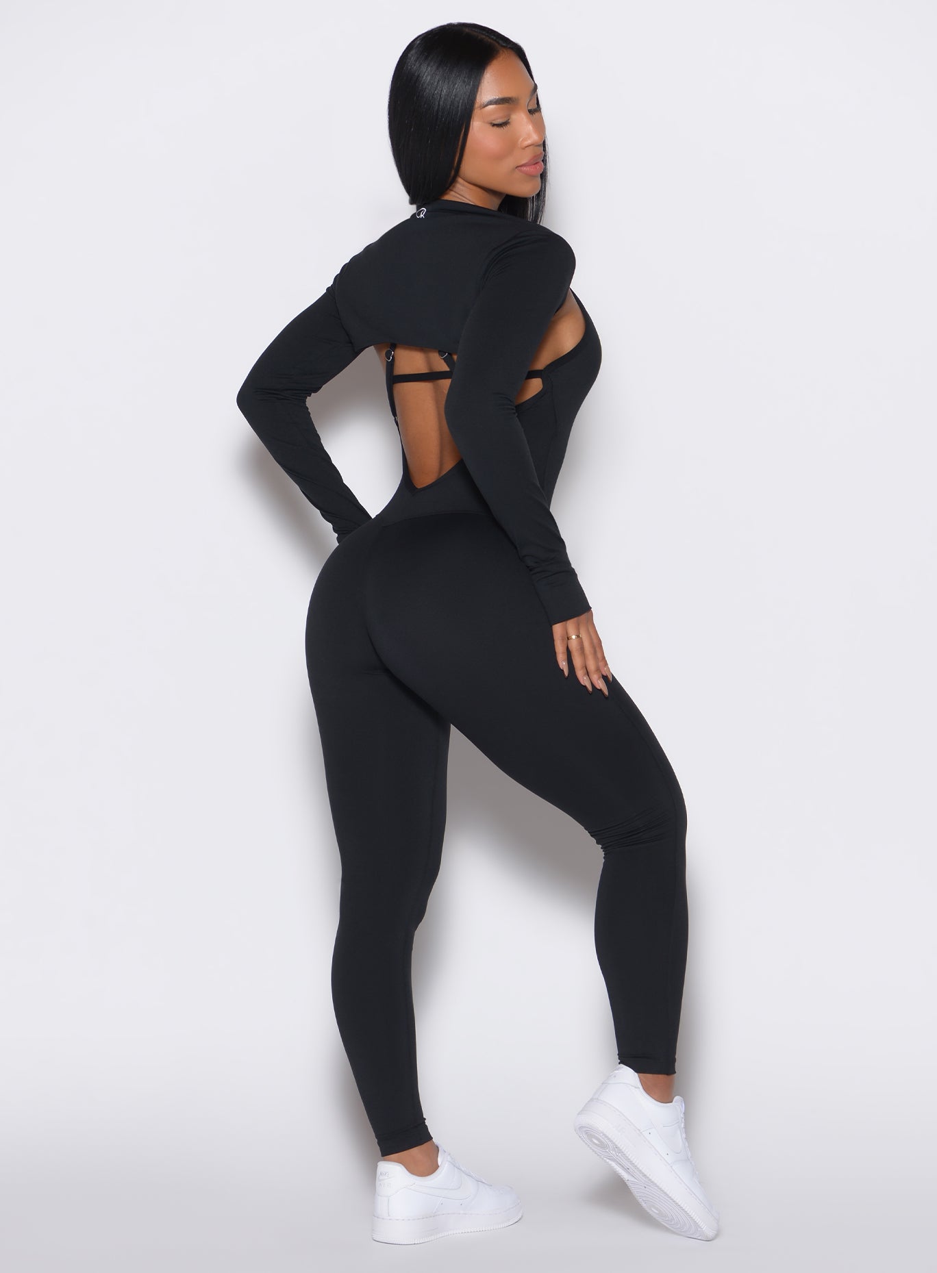 Black Shape Shrug featuring long sleeves with functional thumbholes for a sleek layering look.