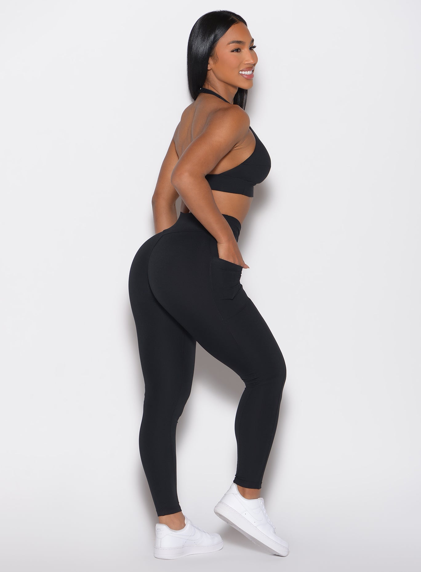 right side profile view of a model wearing the Sculpt Knot Leggings in black color