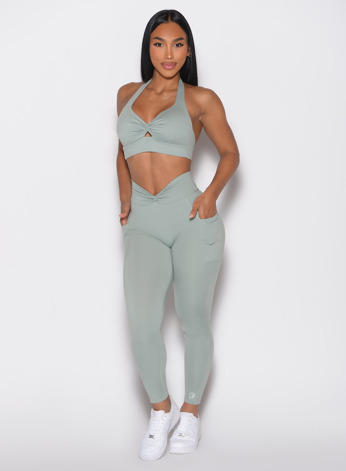 Sculpt Knot Leggings in Iceberg Green with a V-twist front and side pockets for a sculpting gym fit.