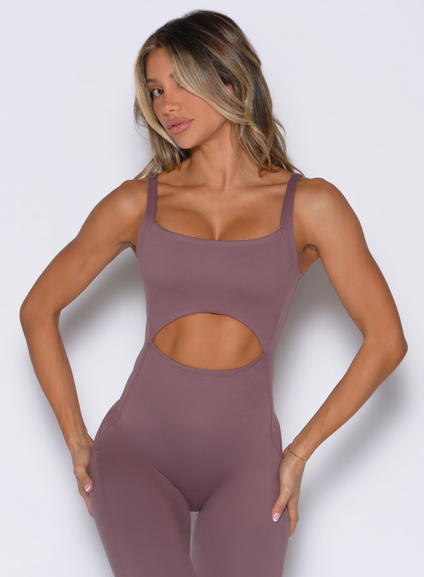 Mauve Sculptura Bodysuit featuring front cutouts and curve-defining seams for an elite gym look.
