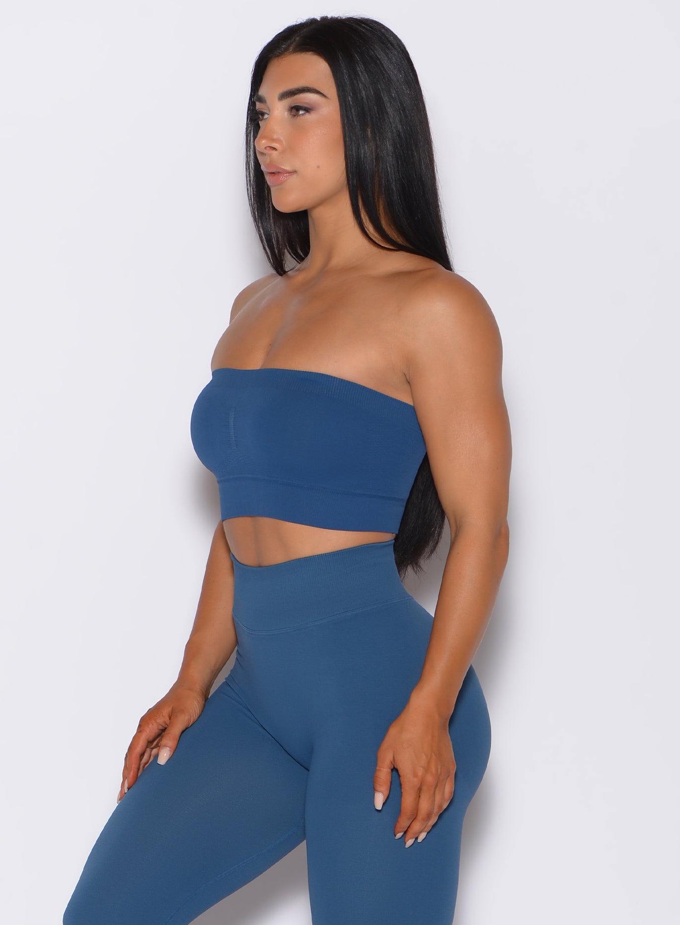 left side profile view of a model angled left wearing our seamless bandeau in galaxy color along with the matching bombshell leggings