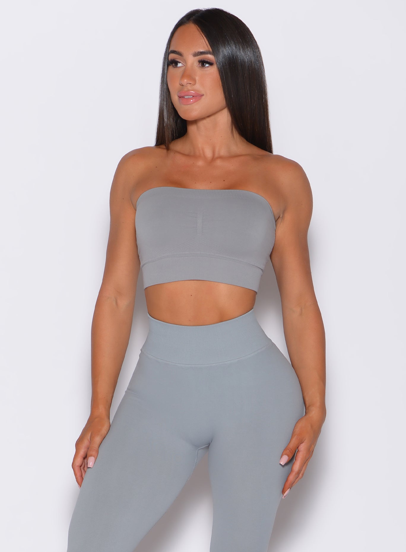 front profile view of a model wearing our seamless bandeau in fog gray color along with the matching leggings