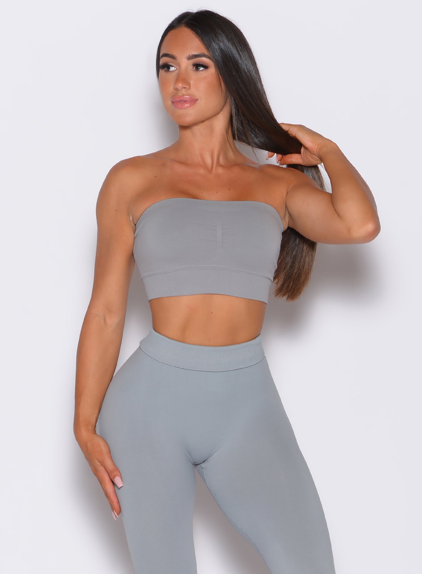 front profile view of a model facing to her right wearing our seamless bandeau in fog gray color along with the matching leggings