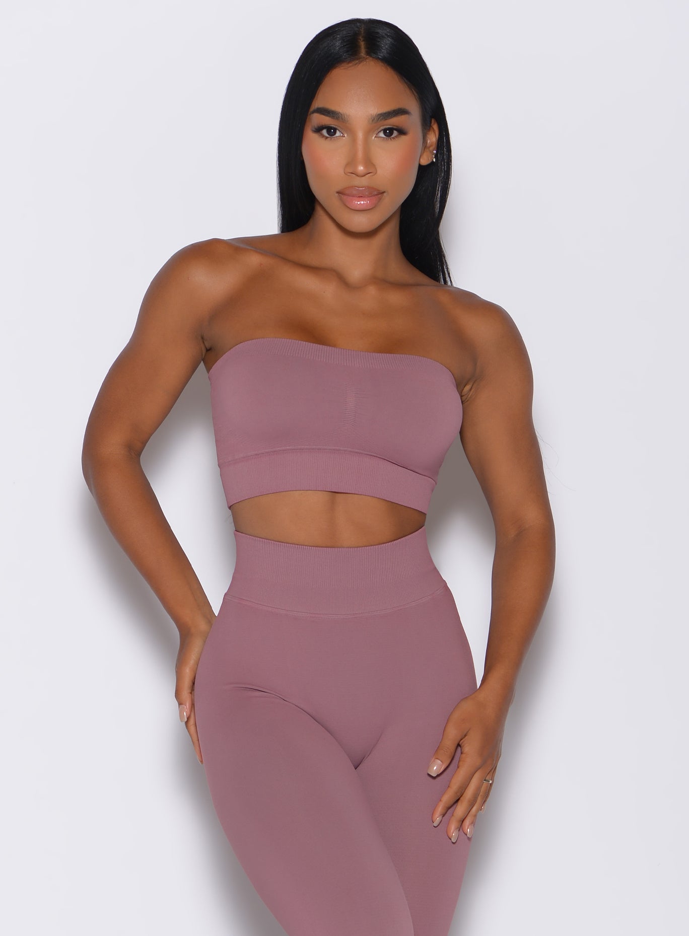 front profile view of a model wearing our seamless bandeau in satin color along with the matching leggings