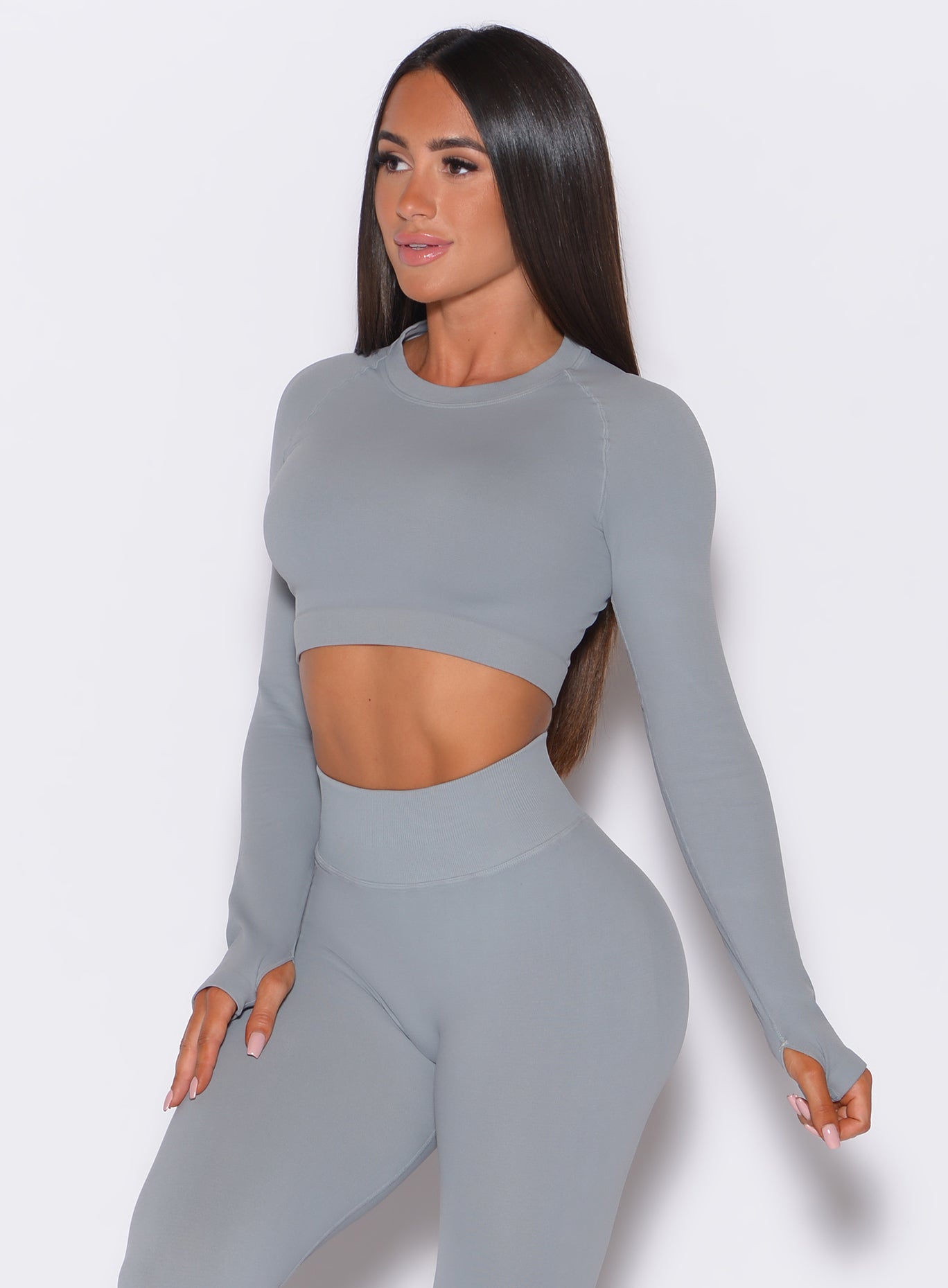 front profile view of a model wearing our seamless pullover in fog gray color along with a matching leggings