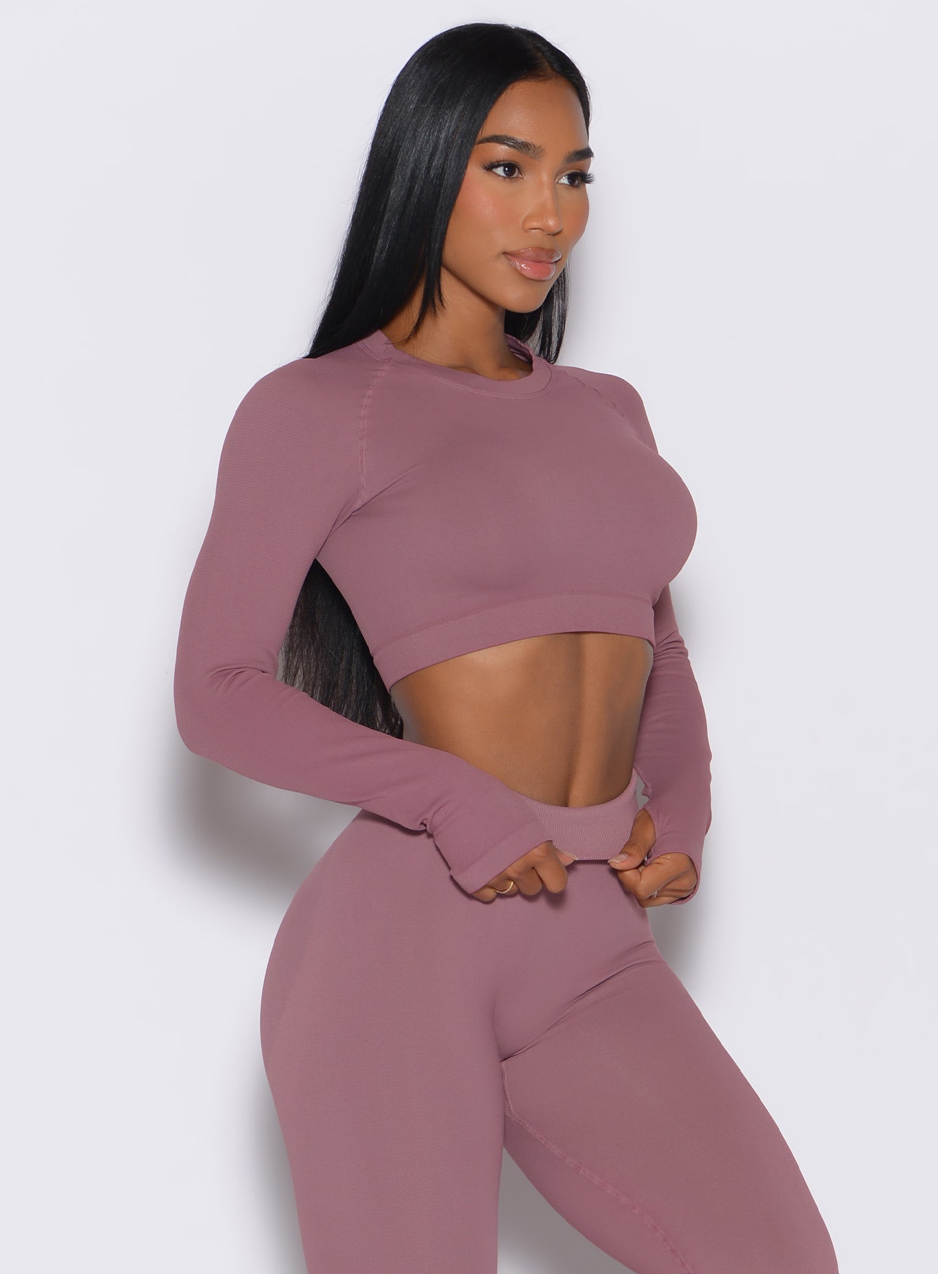 right side side profile view of a model angled right wearing our seamless pullover in satin color along with a matching leggings