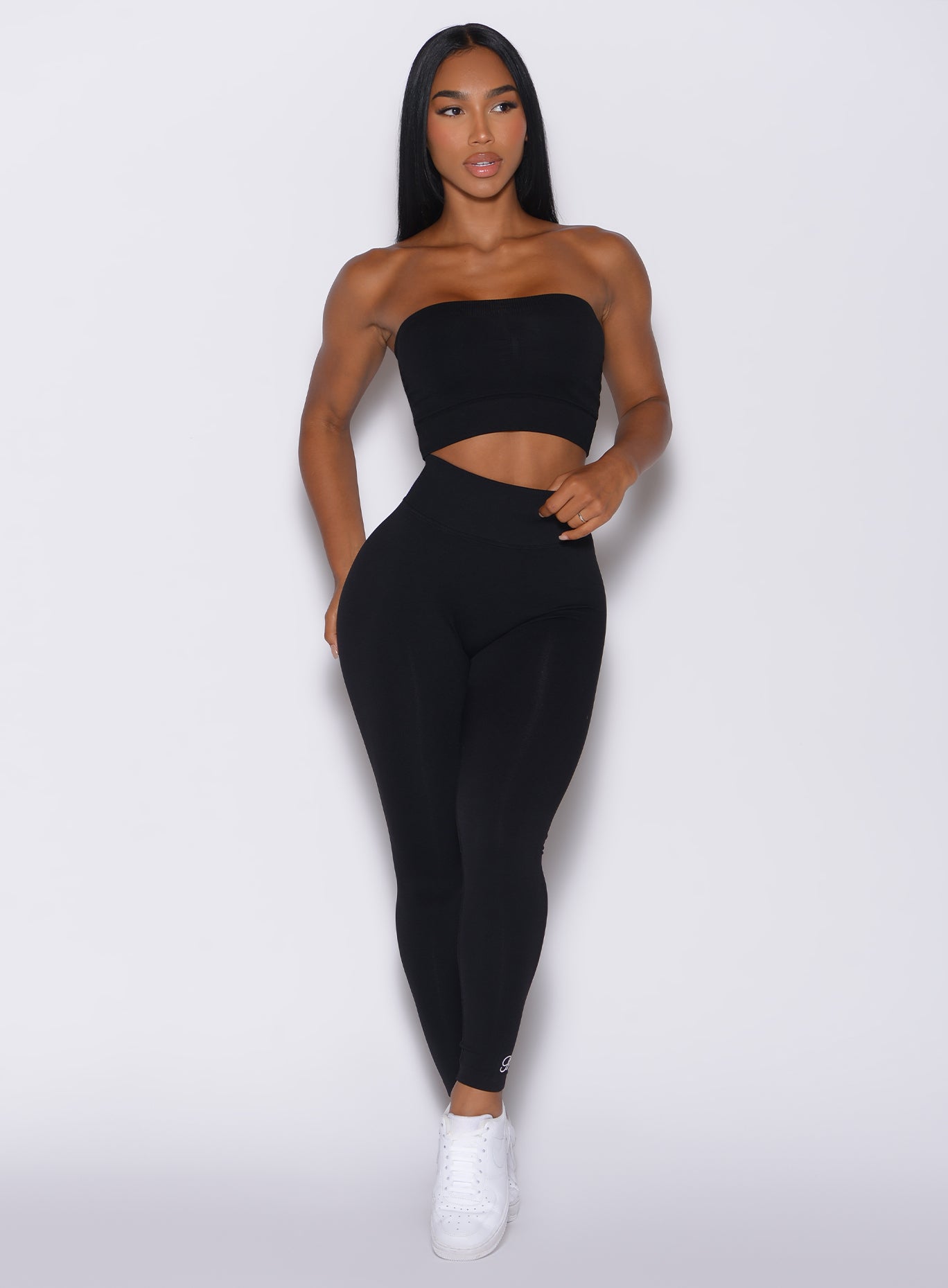 Front profile view of a model wearing our black Cheeky Seamless Leggings along with a matching bandeau