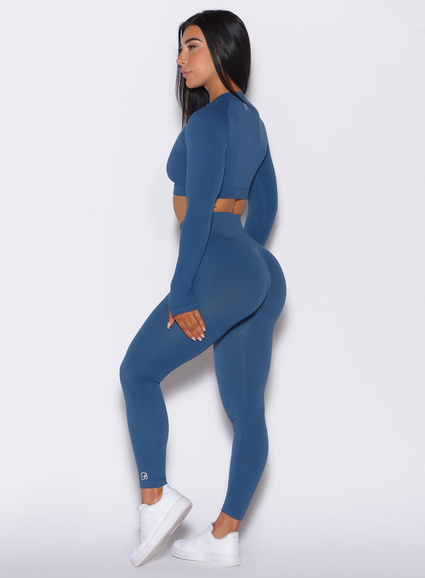 Left side profile view of a model wearing our cheeky seamless leggings in galaxy color along with the matching pullover