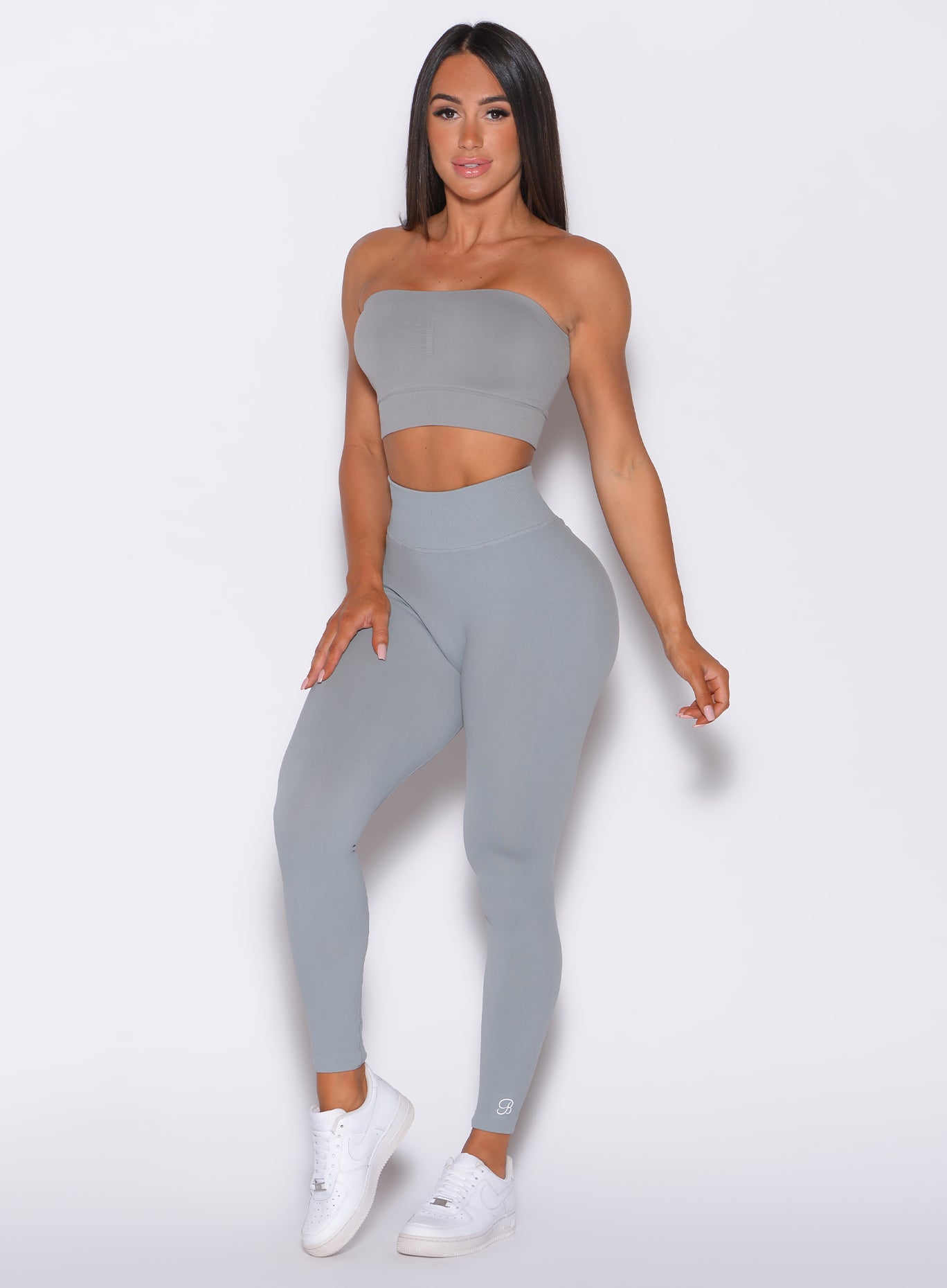Front profile view of a model wearing our cheeky seamless leggings in fog gray color along with a matching bandeau