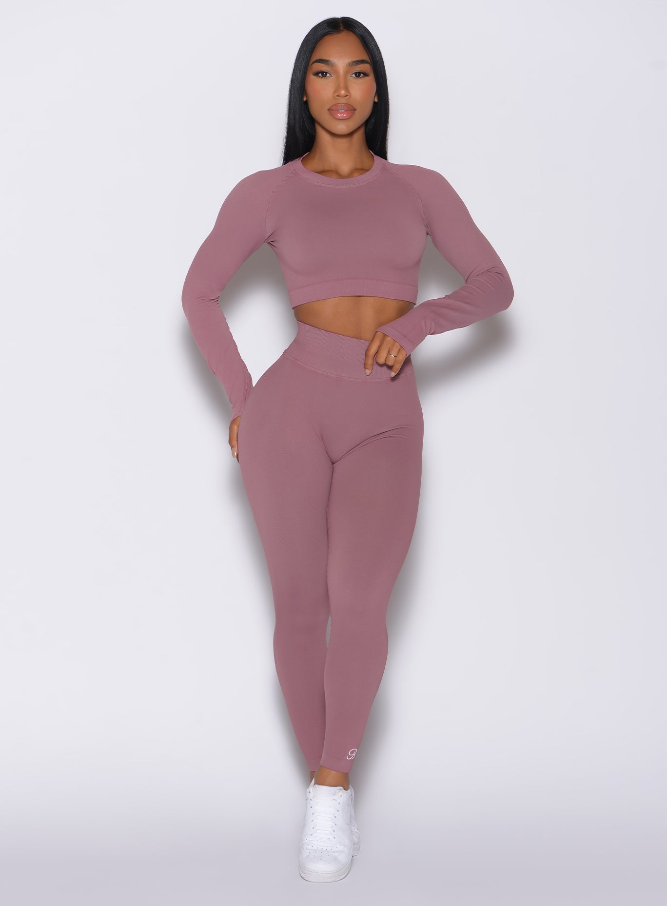 Front profile view of a model wearing our cheeky seamless leggings in satin color along with the matching pullover
