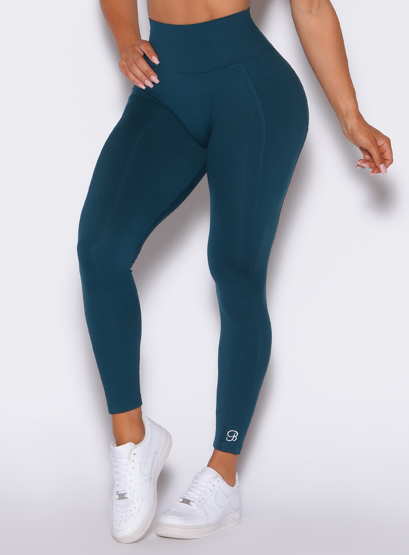 Zoomed in front view of our shape leggings in peacock color