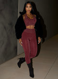 front profile view of a model wearing the Shimmer V Back Leggings in Ruby star color paired with the matching top