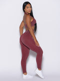 right side profile view of a model wearing the Shimmer V Back Leggings in Ruby star color