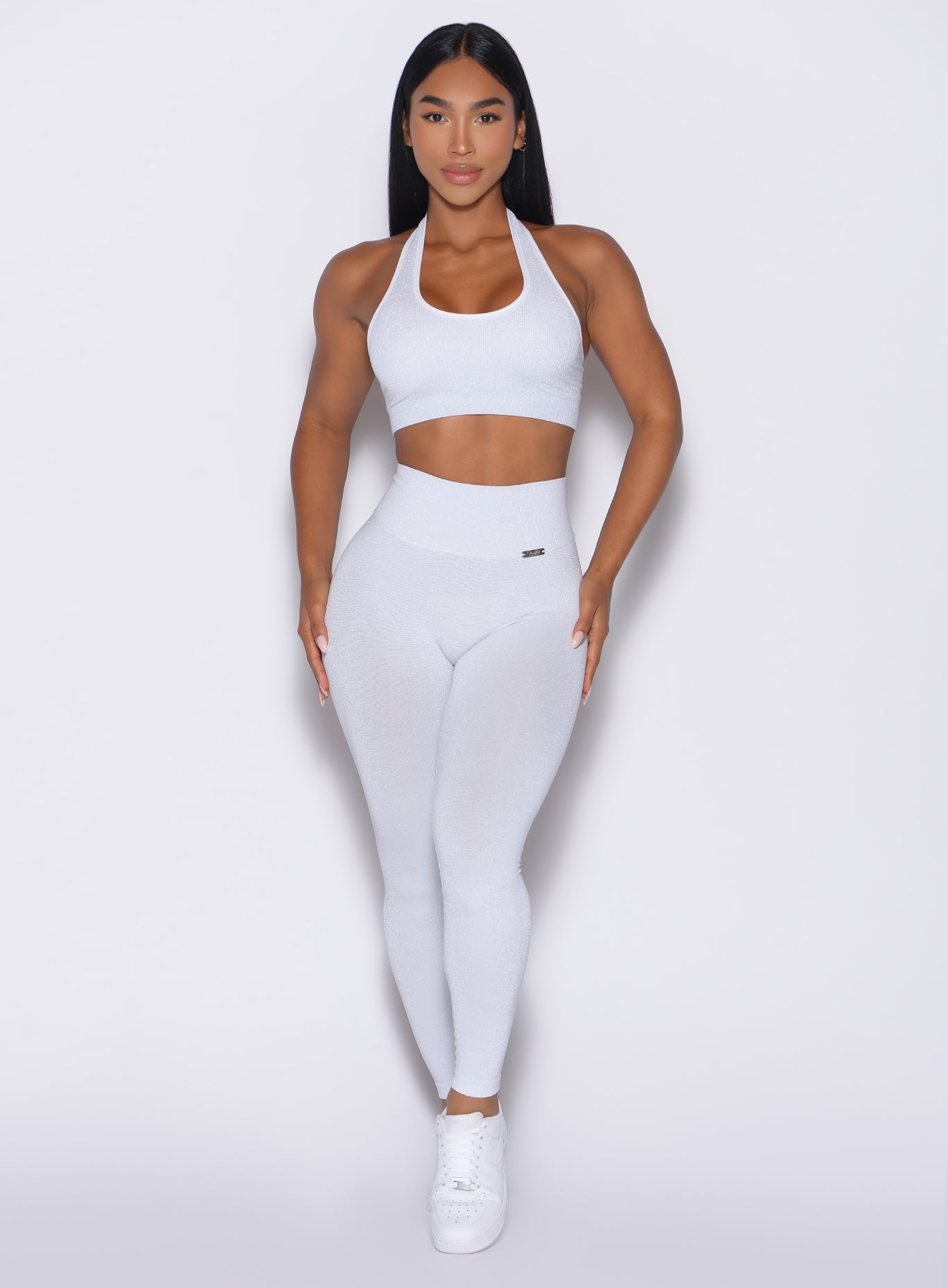 front profile view of a model wearing the Shimmer V Back Leggings in White star color