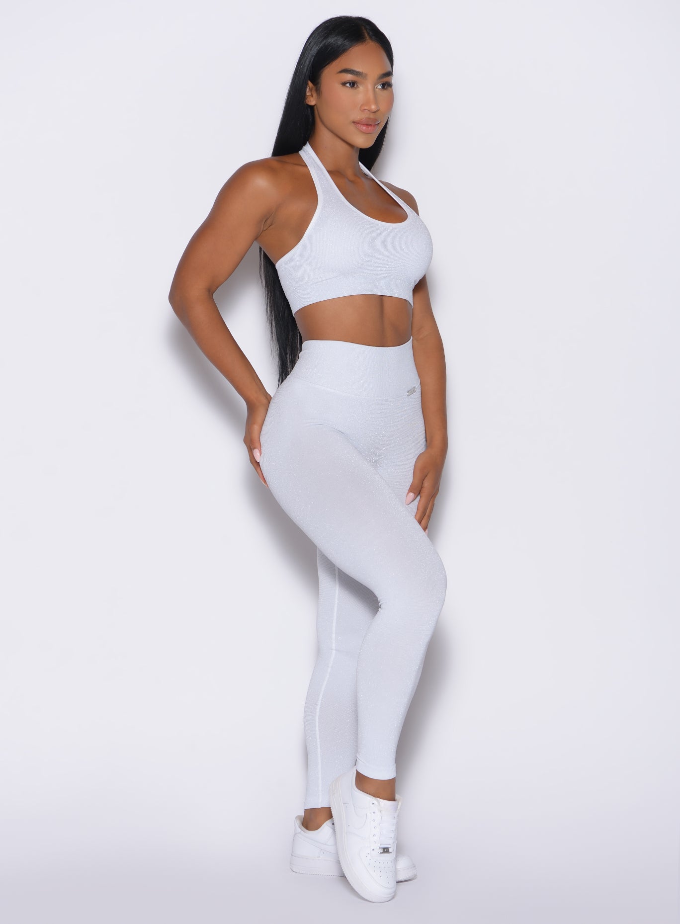front right side profile view of a model wearing the Shimmer V Back Leggings in White star color