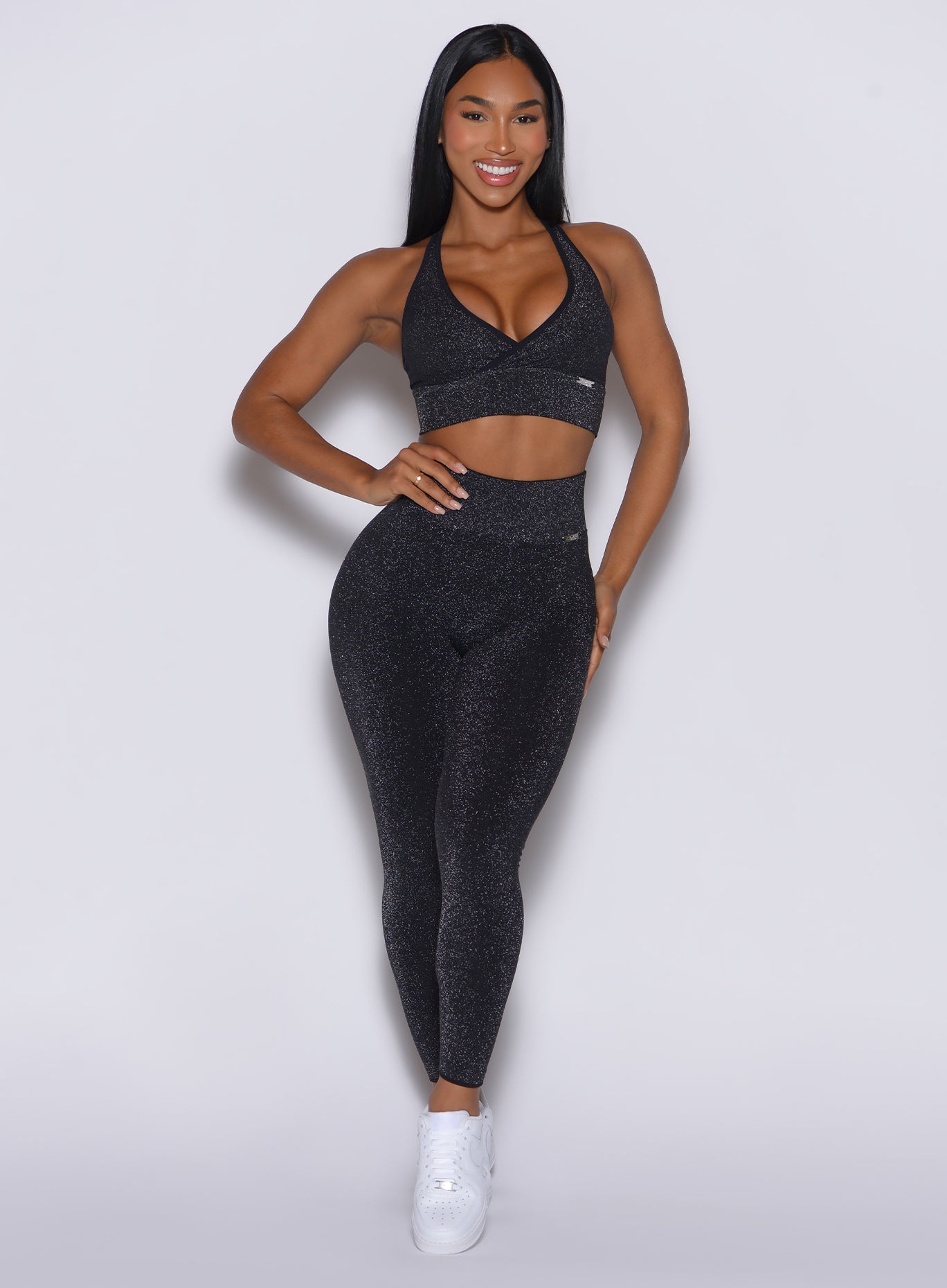 front profile view of a model wearing our Shimmer Seamless Leggings in black sparkle color along with the matching shimmer bra