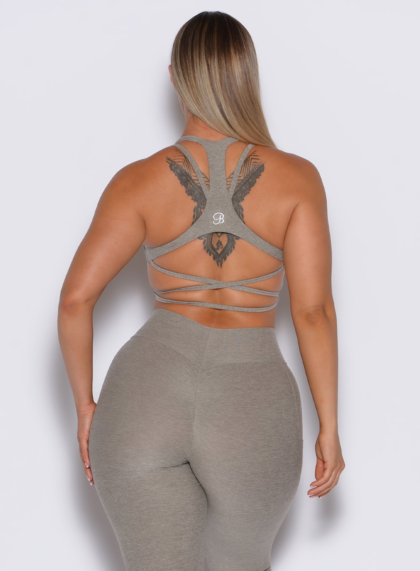 back profile picture of a model wearing our viral tank bra in nori color along with the matching curves leggings