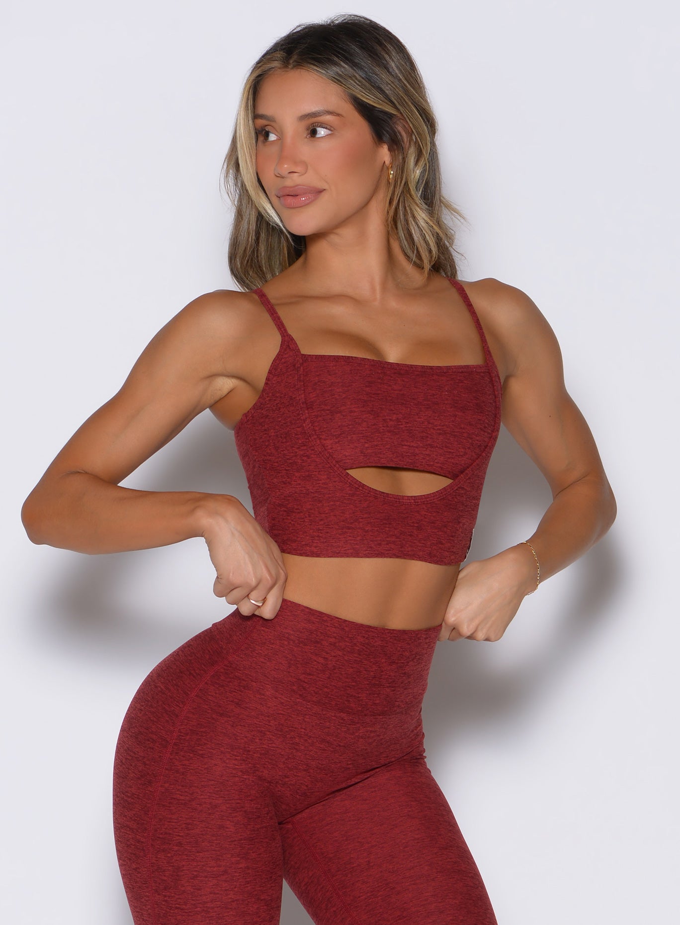 front profile view of a model facing to the right side wearing the Studio Sculpt Bra in Rouge color