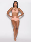 front profile view of a model with both hands on her waist wearing the Sunkissed Sparkle Swim Shorts in Golden Hour color