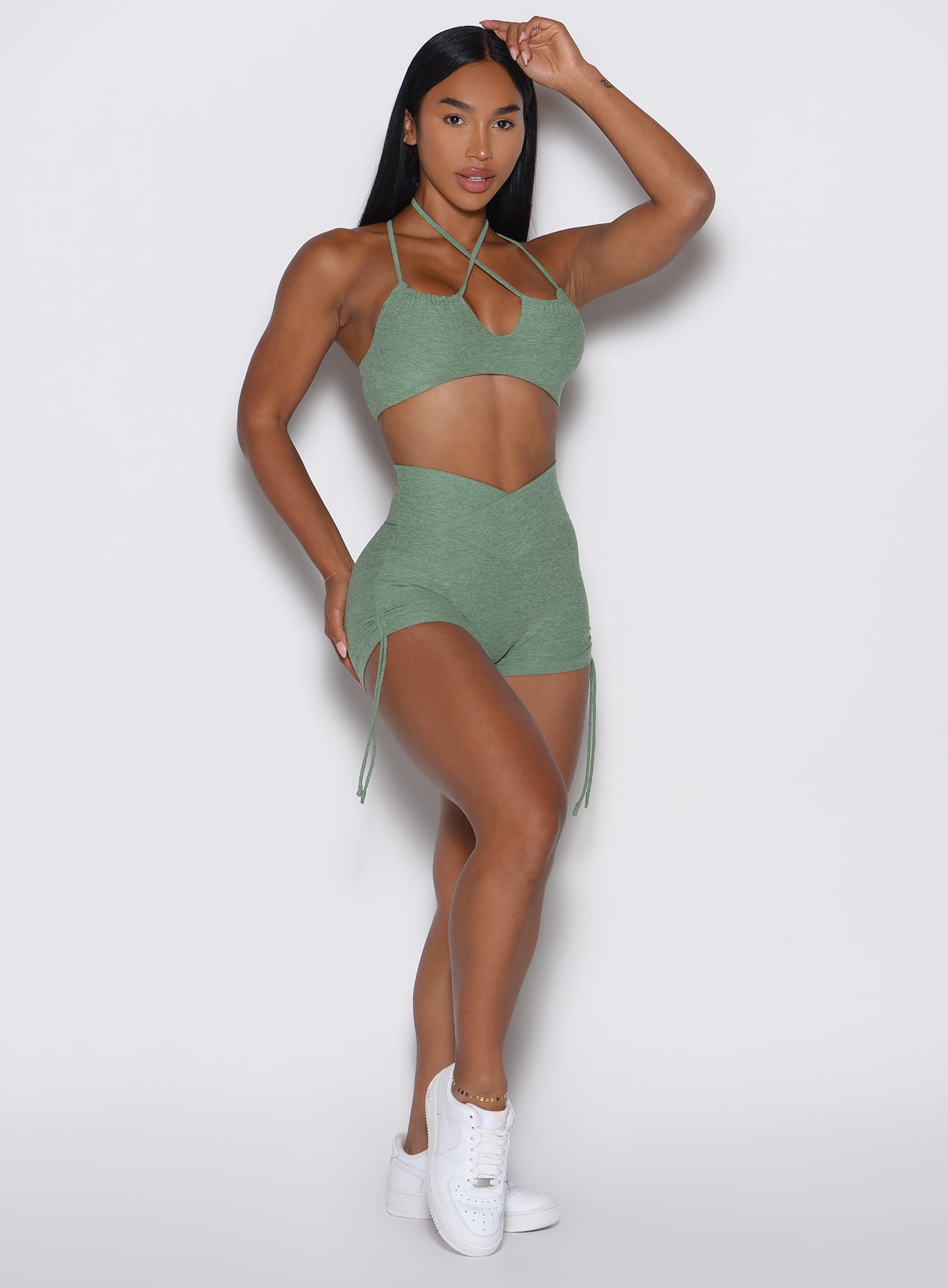 front profile view of a model wearing the Tiny Waist Tie Shorts in basil color
