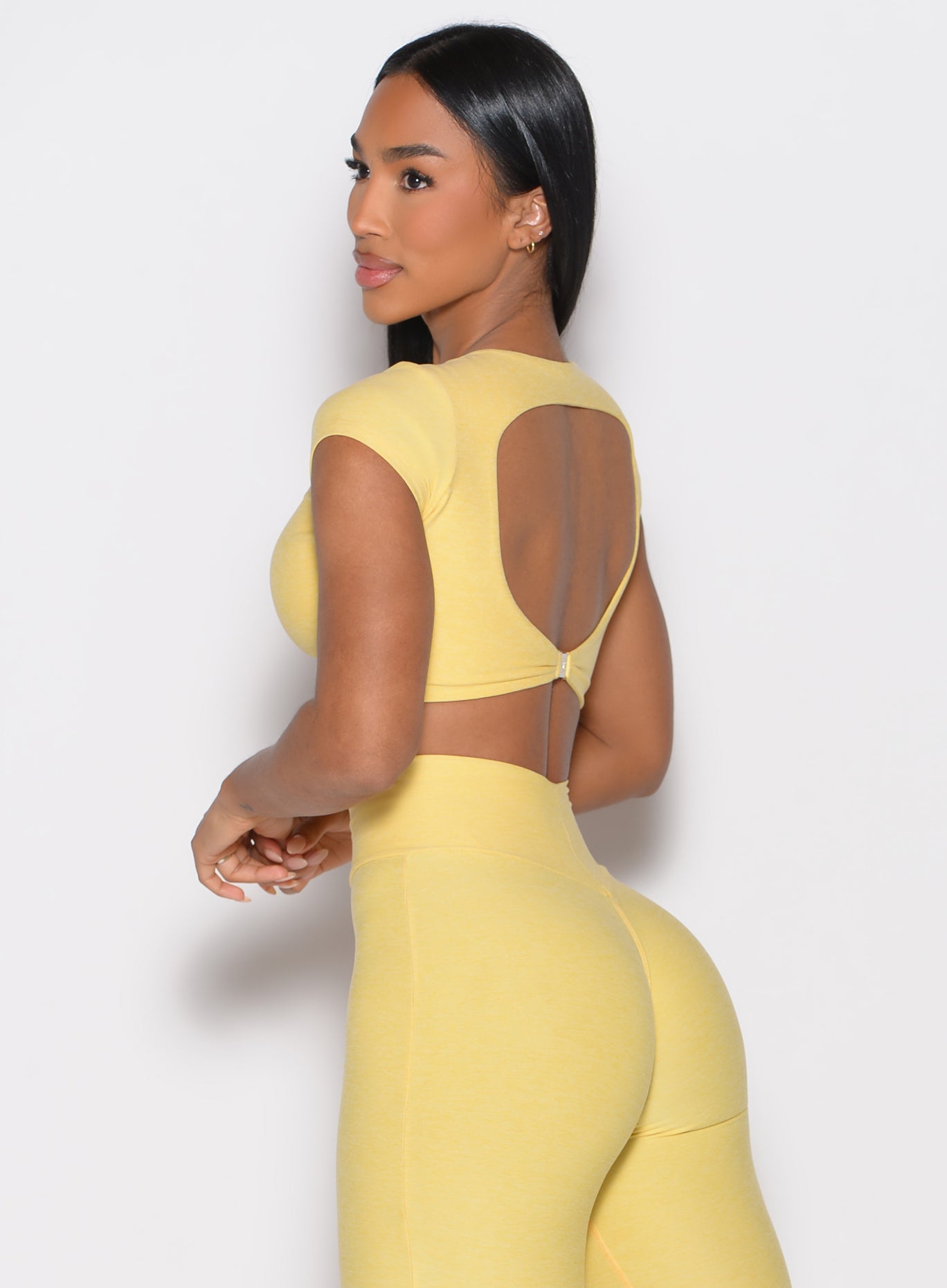 back left side profile view of a model wearing the Toggluxe Tee in Lemon color