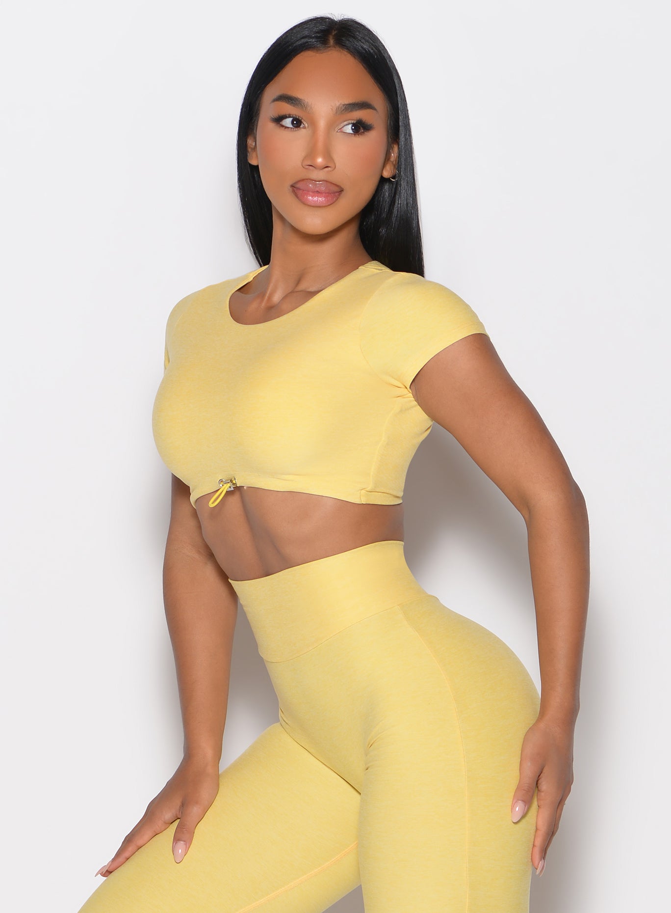 front left side profile view of a model wearing the Toggluxe Tee in Lemon color
