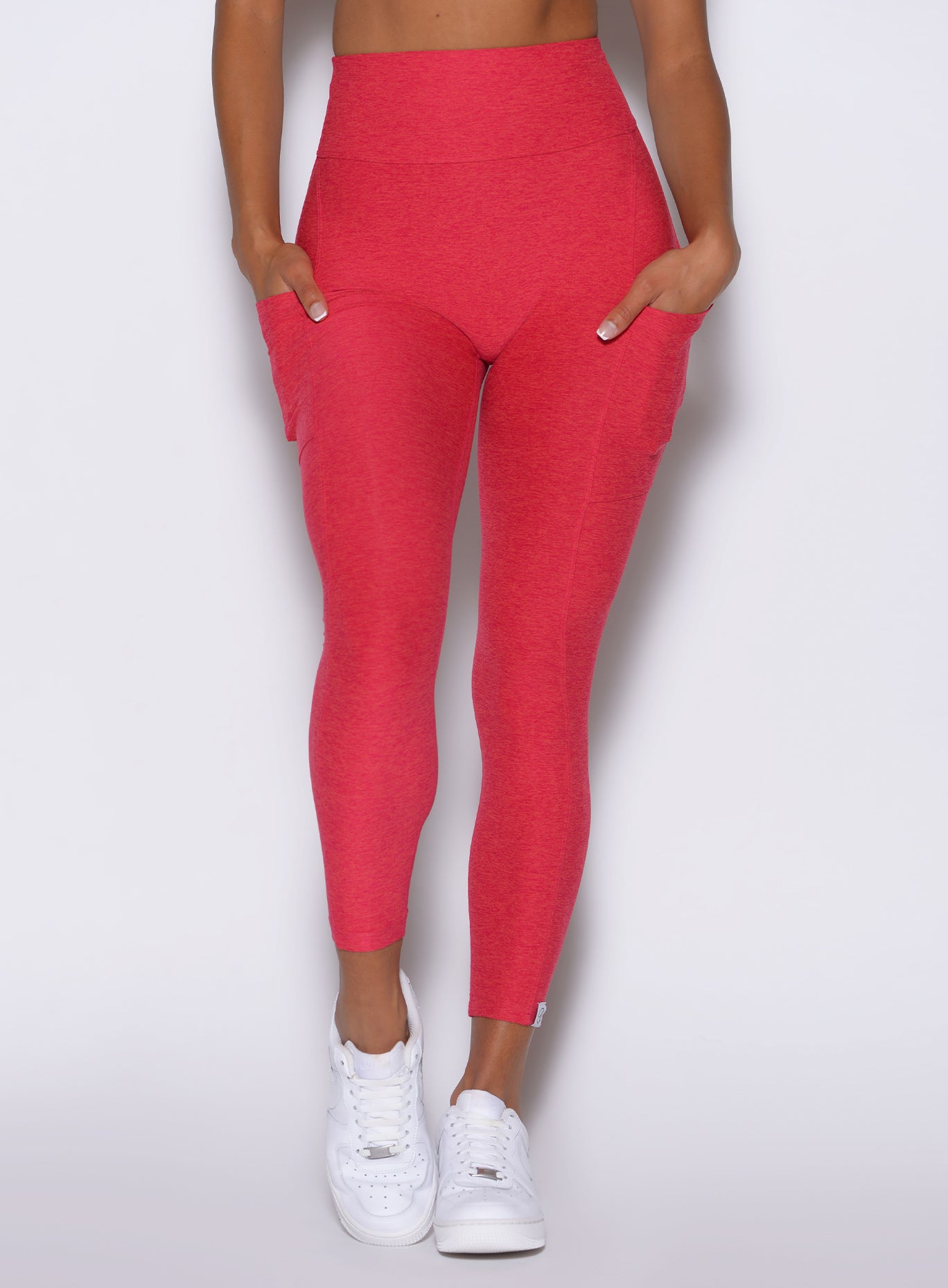 zoomed in front view of a model wearing the Toned 7/8 Leggings in Victory Ruby color