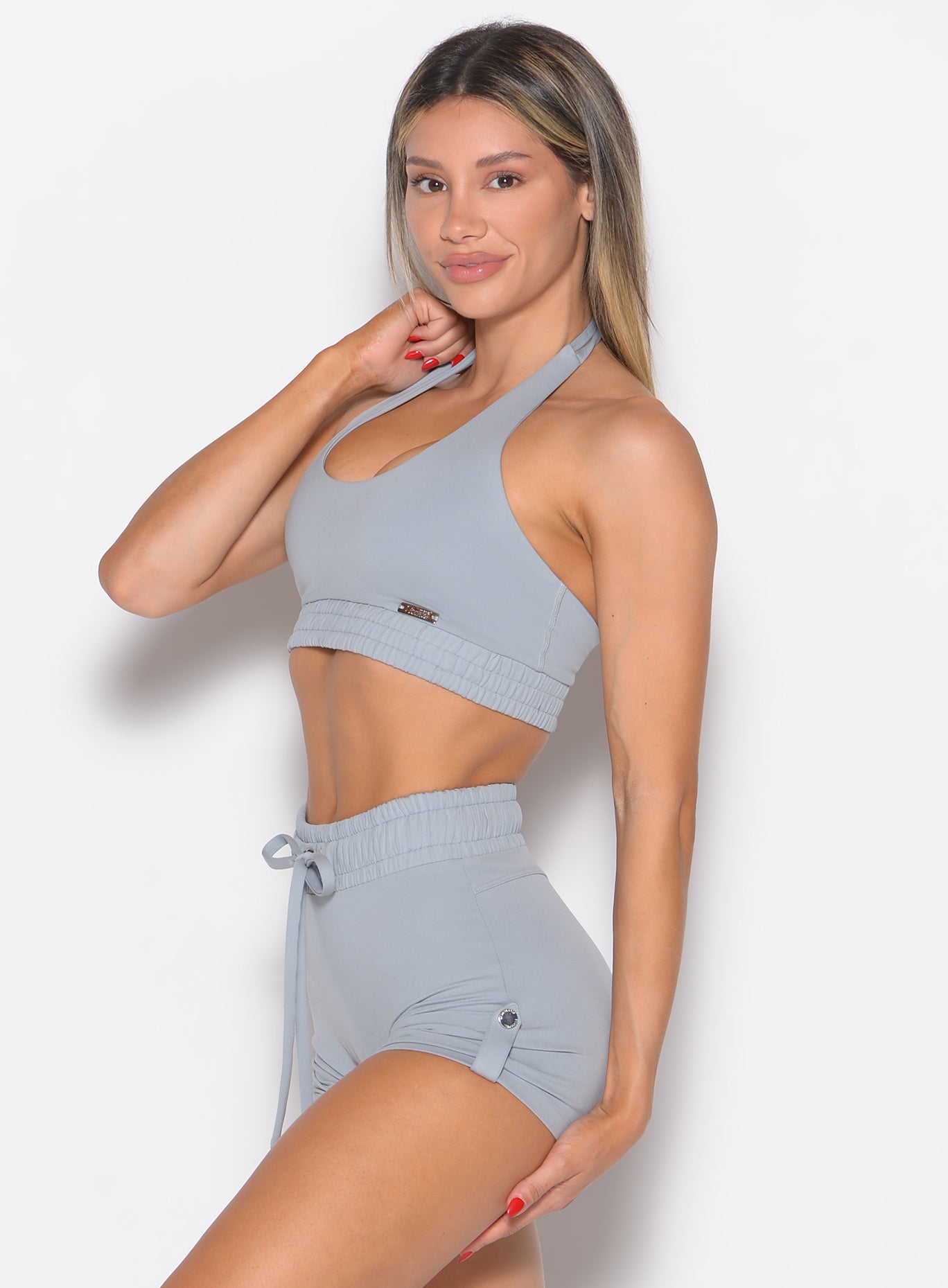 left side profile view of a model wearing the Trailblaze Sports bra in quarry color