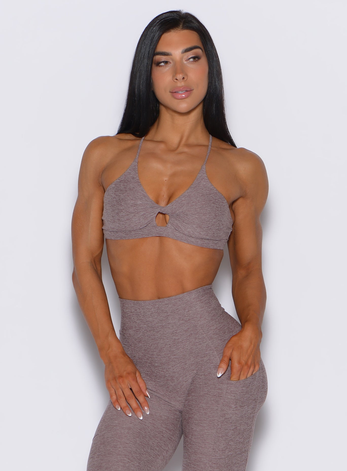 front profile vew of a model wearing our tiny twist bra in london fog color along with the matching leggings