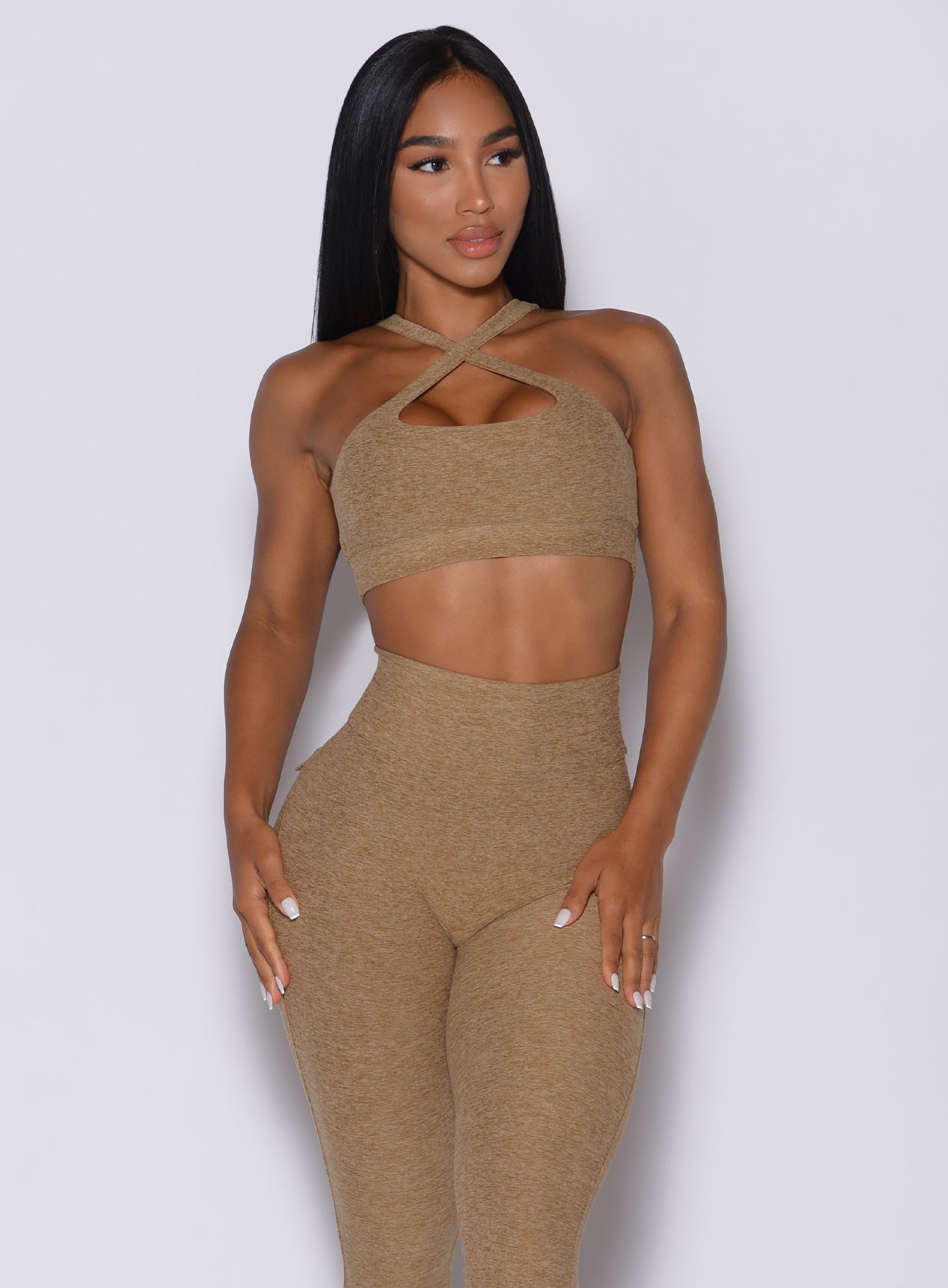 front profile picture of a model in our two way sports bra in caramel color and a matching leggings