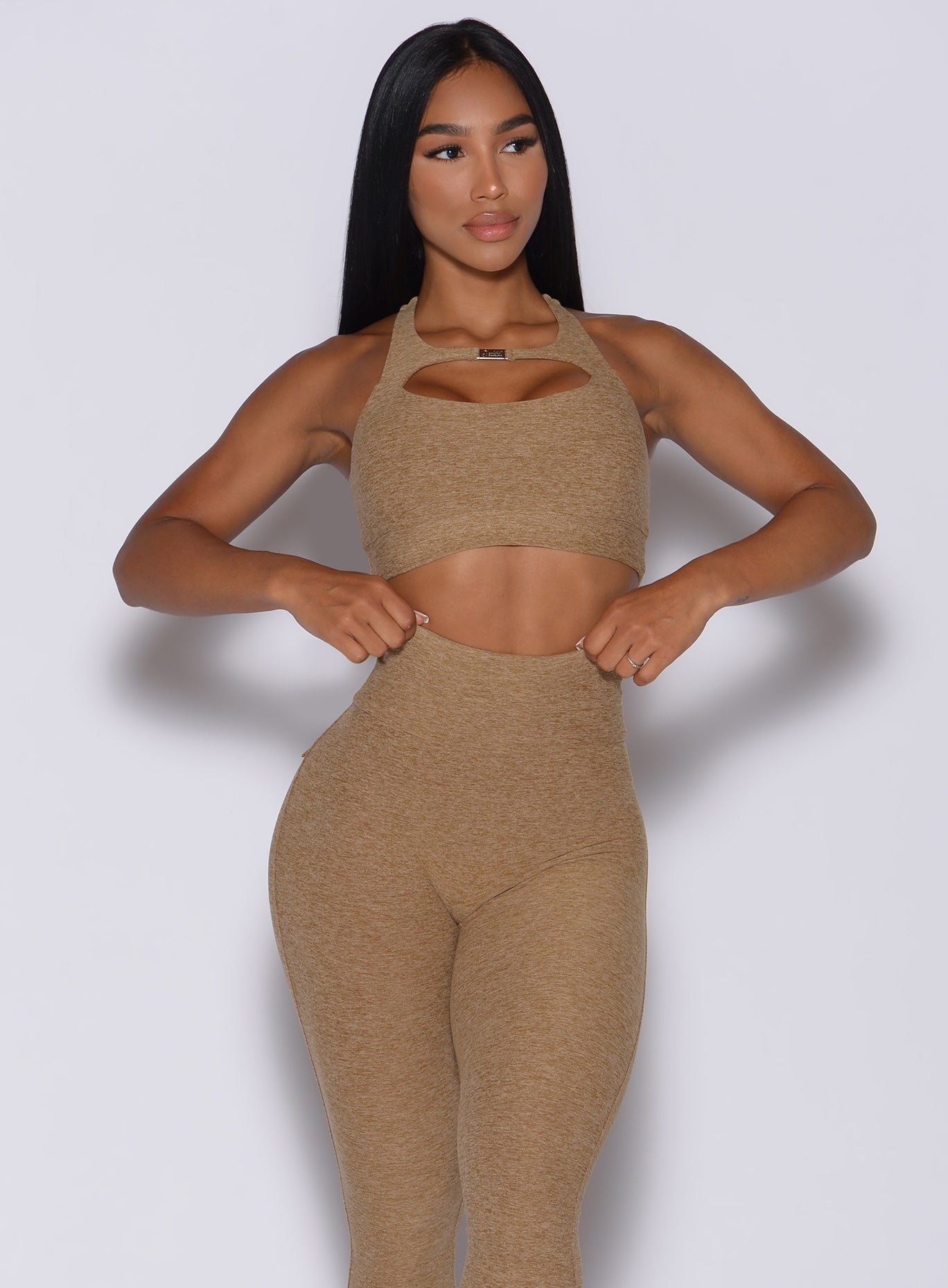 front profile picture of a model wearing our two way sports bra in caramel color and a matching leggings