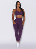 Model facing forward wearing our V back leggings in purple passion color and a matching bra