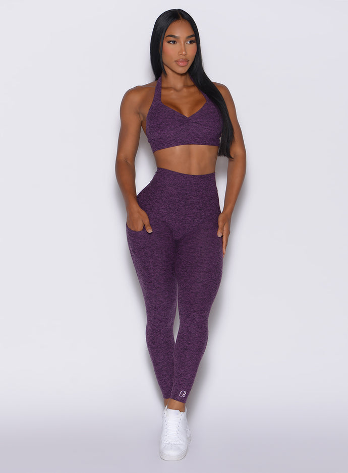 Model facing forward wearing our V back leggings in purple passion color and a matching bra