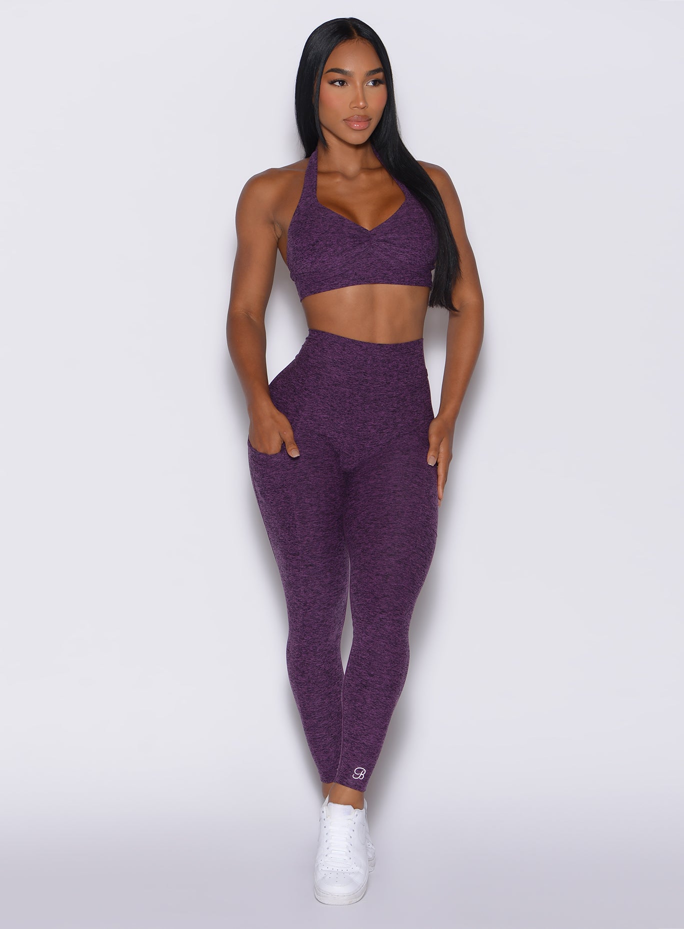 Model facing forward wearing our V back leggings in purple passion color and a matching bra
