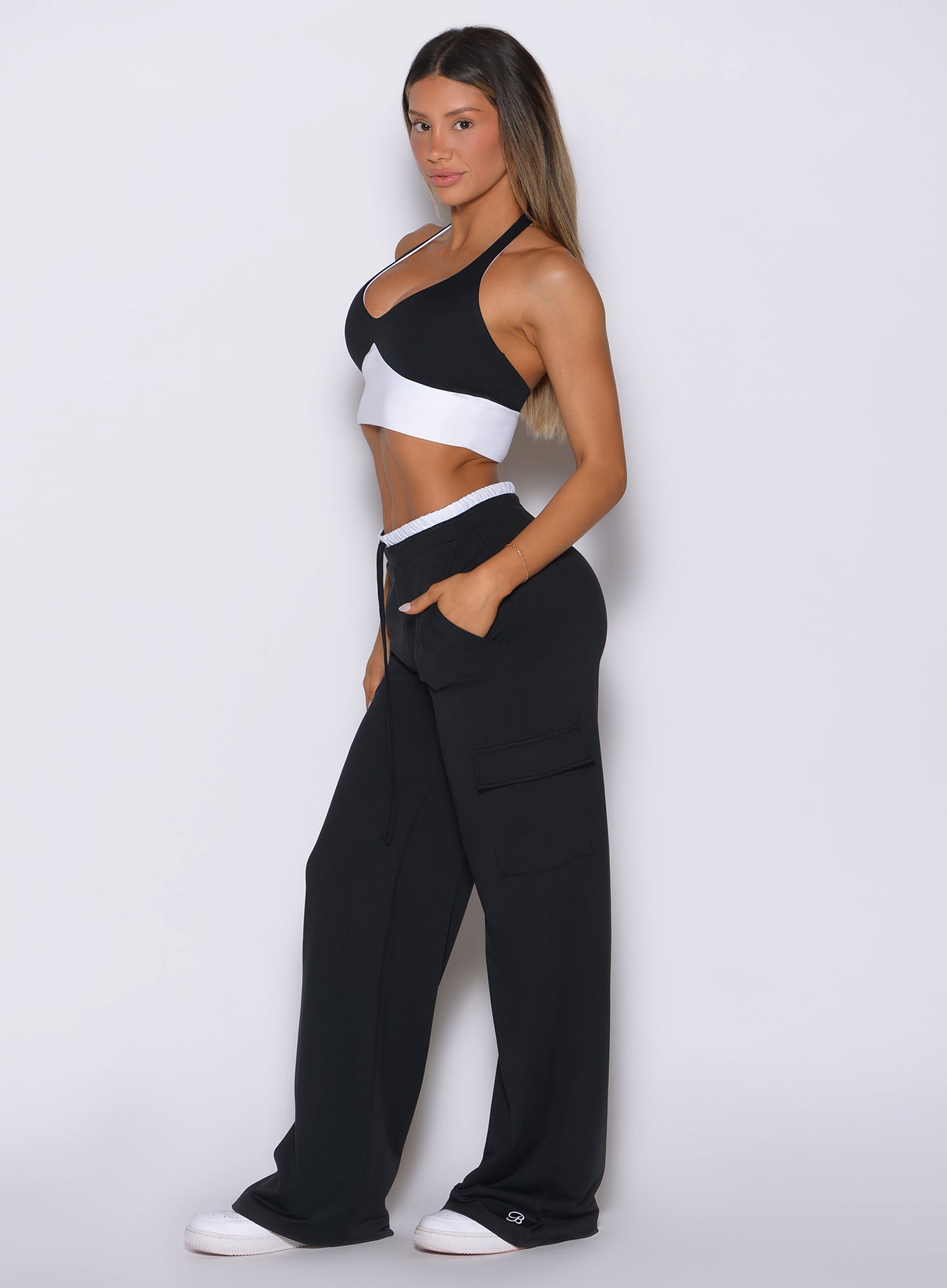 Bombshell Sportswear black lounge outfit right side angle with supportive halter bra and high-waist wide-leg cargo pants designed for flattering curves, second-skin comfort, and luxury active lounge style