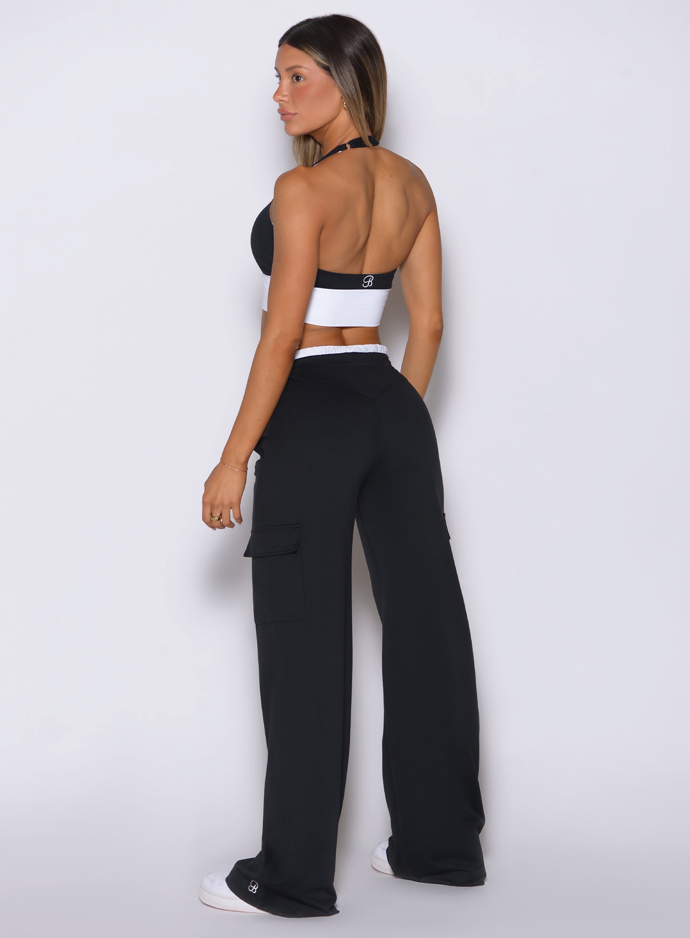 Back view of model facing left, wearing Bombshell Sportswear wide leg joggers in Black color with relaxed flowy fit