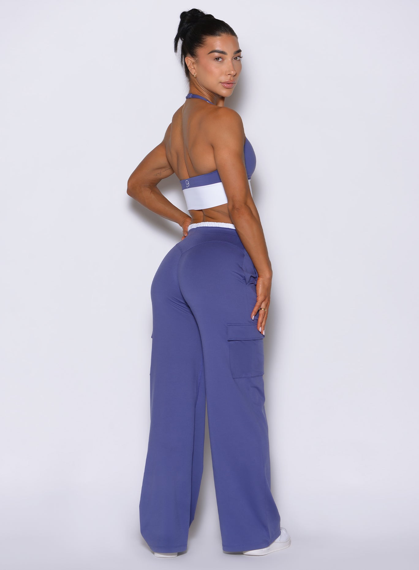 Back right view of model posing and looking right, wearing bombshell sportswear wide leg joggers in Future Dusk color with relaxed flowy fit