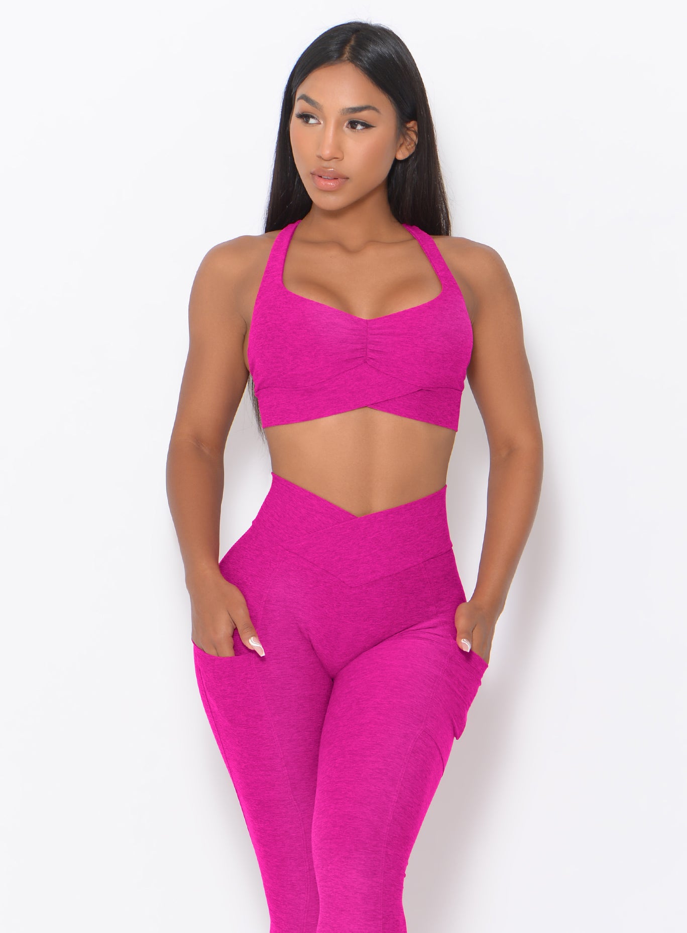 front profile view of a model wearing our Angel Sports bra in Ultra Pink color