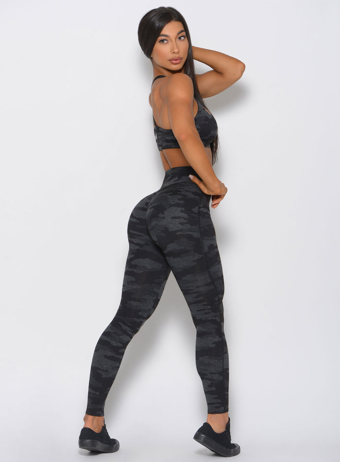 Right side profile of the model in the Fit Camo Leggings in charcoal color.