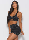 Side profile of the model angled left wearing the charcoal black army camo shorts