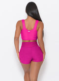 Zoomed in back side view of a model in our Curves Shorts in Ultra Pink color and a matching Sports Bra