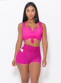 Zoomed in front view of a model in our Curves Shorts in Ultra Pink color and a matching Sports Bra